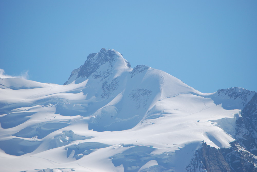 Dufourspitze med mere zoom på lang avstand. Stiene opp og ned breen kan sees her